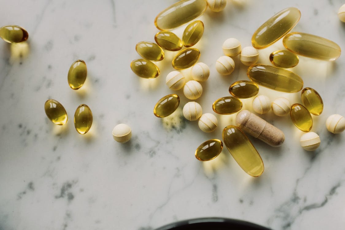 Free White and Green Medication Pills on Gray Surface Stock Photo