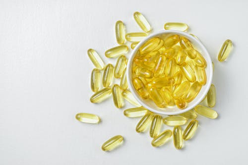 653afb5da331226e7f4121bd free photo of flat lay of fish oil gold capsule on background food supplement vitamin d vitamin e omega 3 jpeg