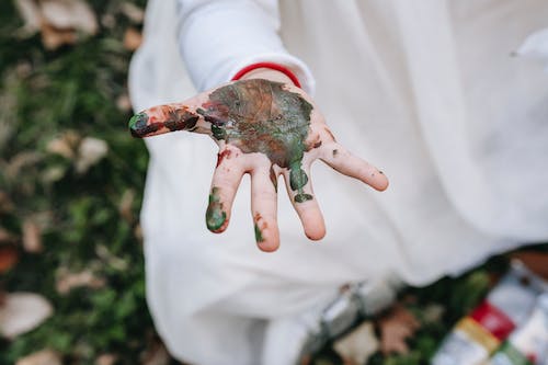 Free Girl sitting on grass and showing dirty hand Stock Photo